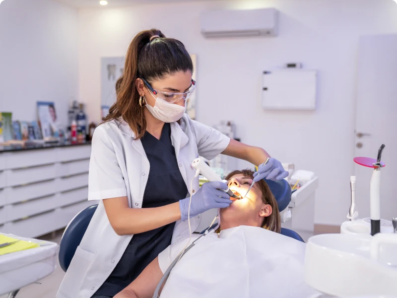 Woman dentist treating patient in office.