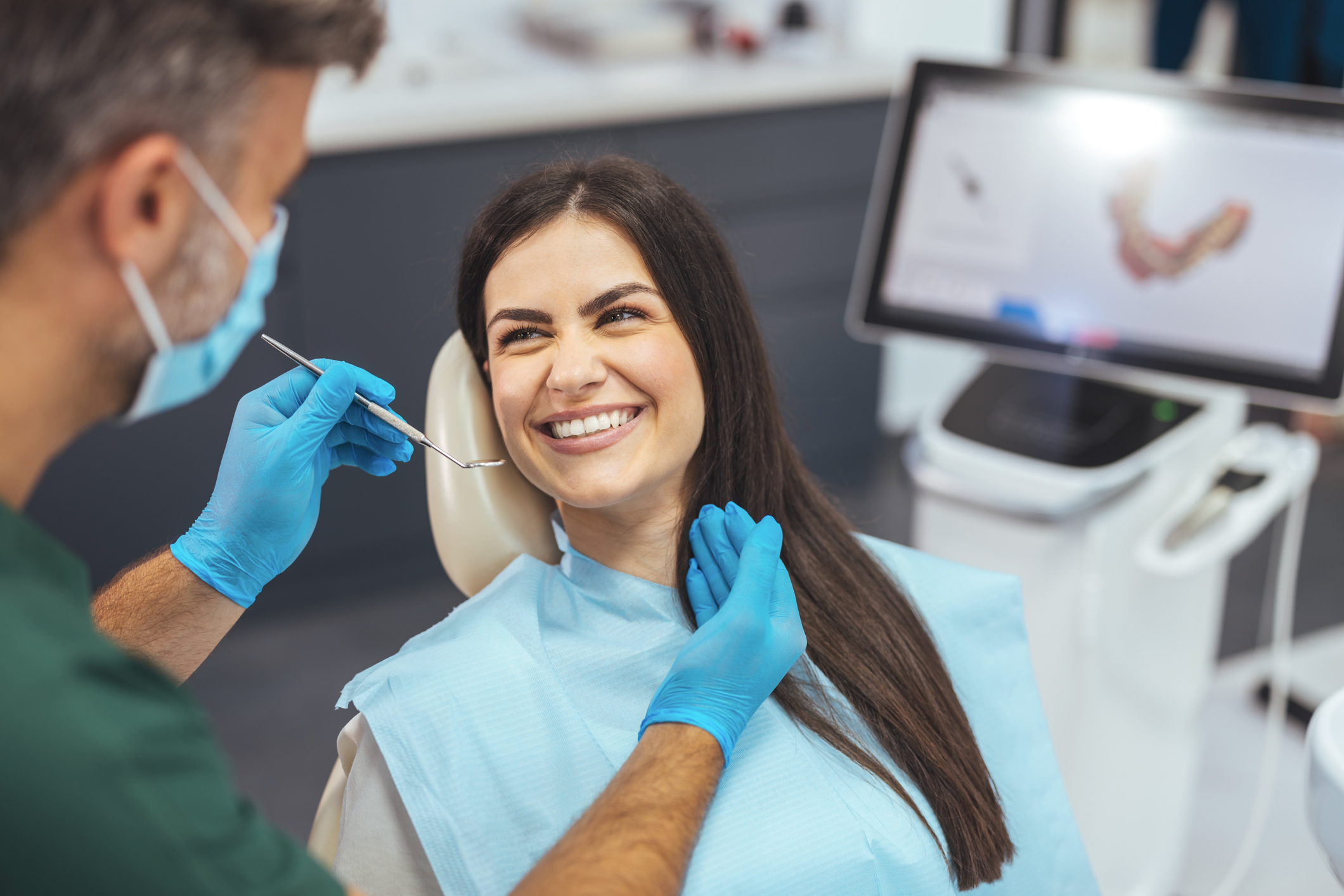 Attractive woman at the dental office. Dentist examining patient's teeth in clinic.